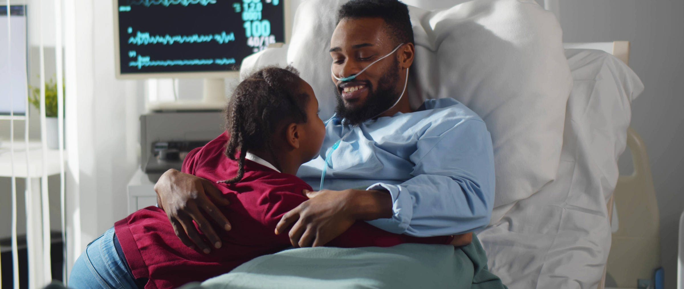 Father in hospital visiting with young daughter