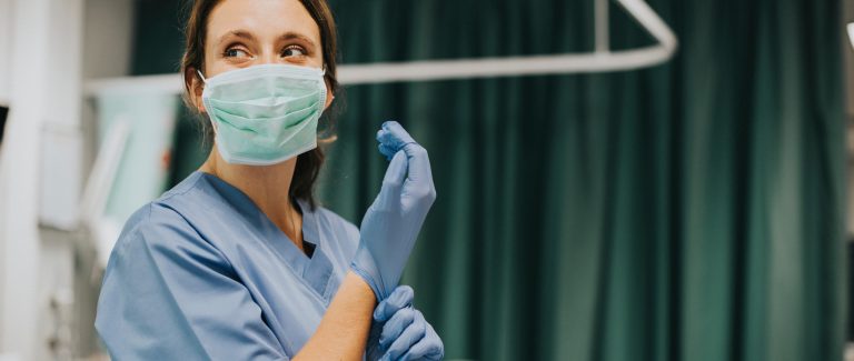 Enfermera poniéndose un guante en urgencias