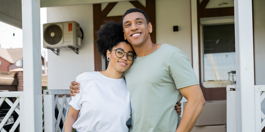 a couple outside their home as homeowners